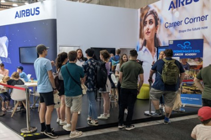 Besucher am Airbus-Messestand mit Roll-up der DroneMasters Junior Academy