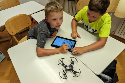 Zwei Kinder programmieren eine Drohne