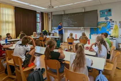 Trainer erklärt Grundschulkindern im Klassenzimmer die Welt der Drohnen