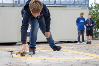 A participant of the DroneMasters Academy positions a drone on the launch pad